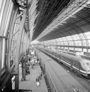 881968 Gezicht op de perrons onder de tweede perronkap van het N.S.-station Amsterdam C.S. te Amsterdam.